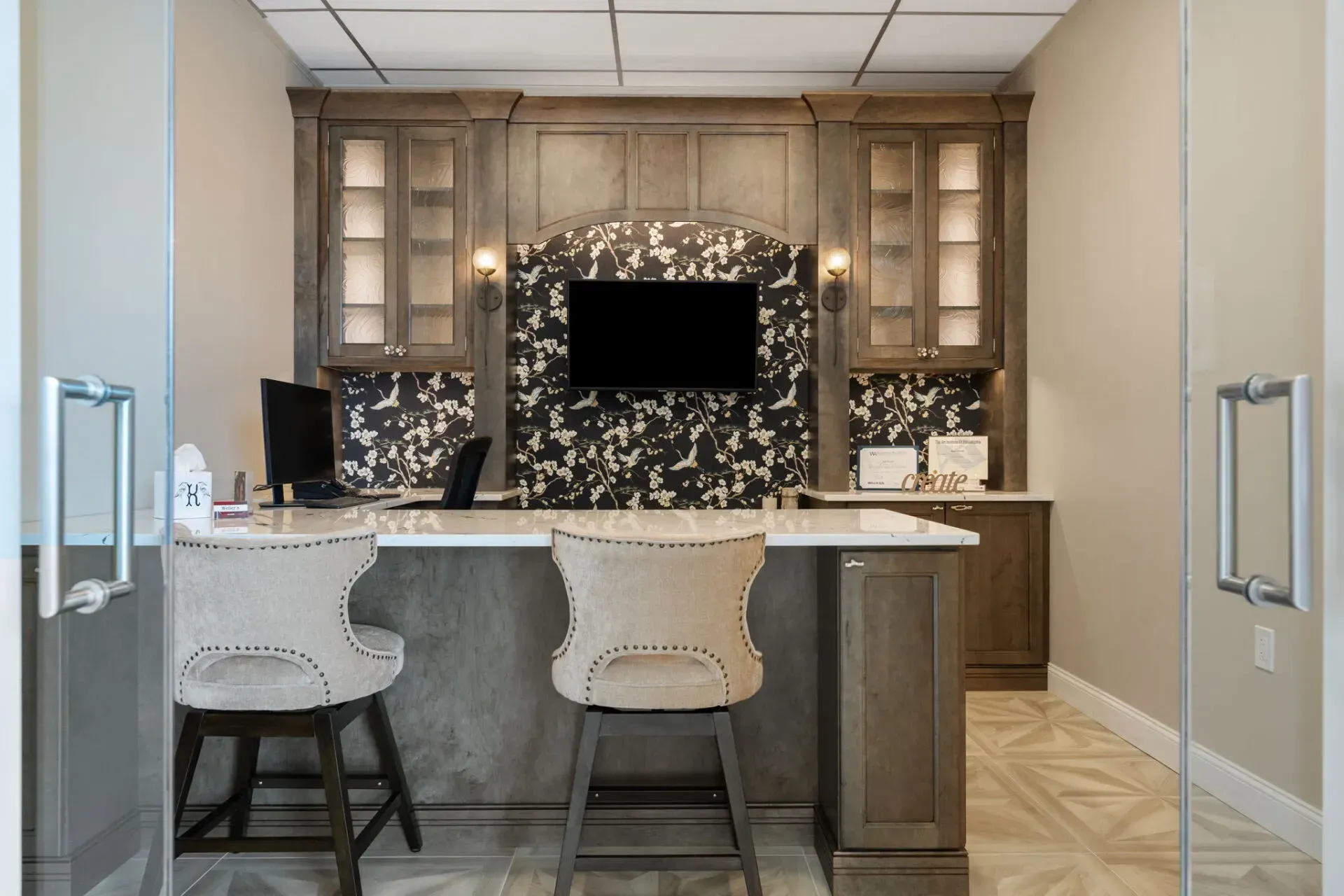 Built-in home office nook with marble desk, two stools, and a TV centered on a tiled accent wall  In Bucks County PA