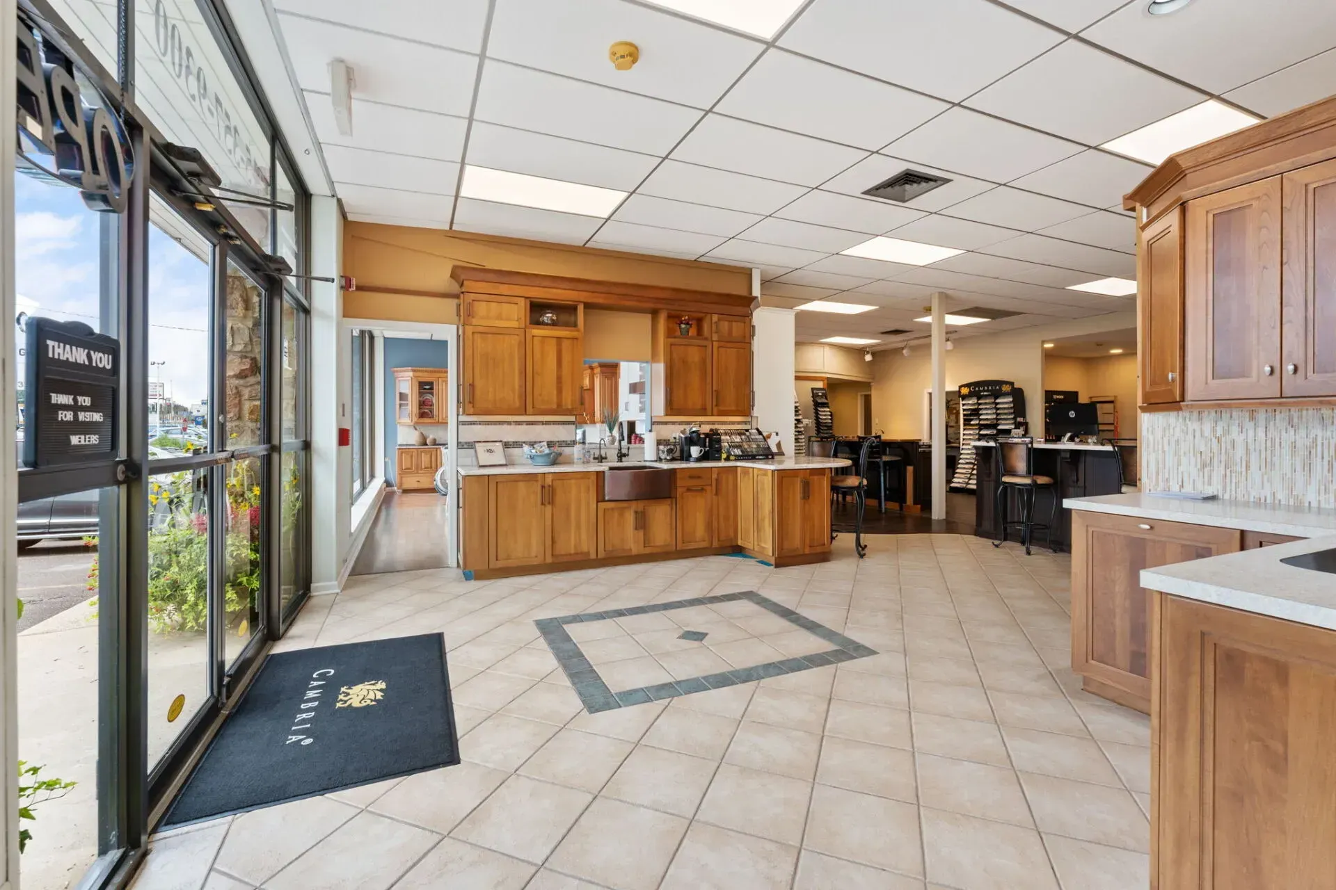 Bright lobby with wood cabinets, tiled floor, glass entrance, and reception counter In Bucks Country PA