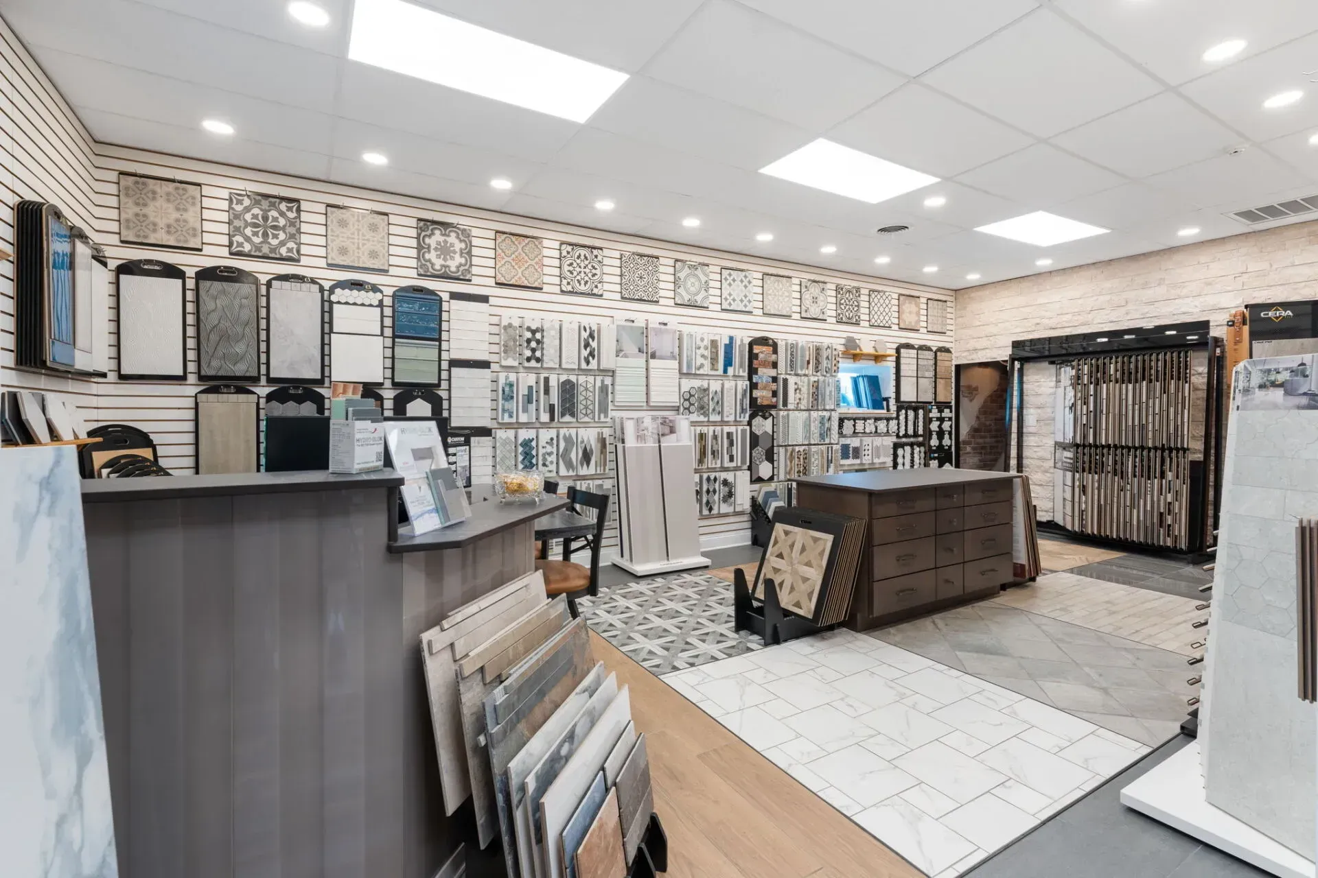 Bright flooring showroom with tile, carpet, and wall samples under fluorescent lights  In Bucks County PA