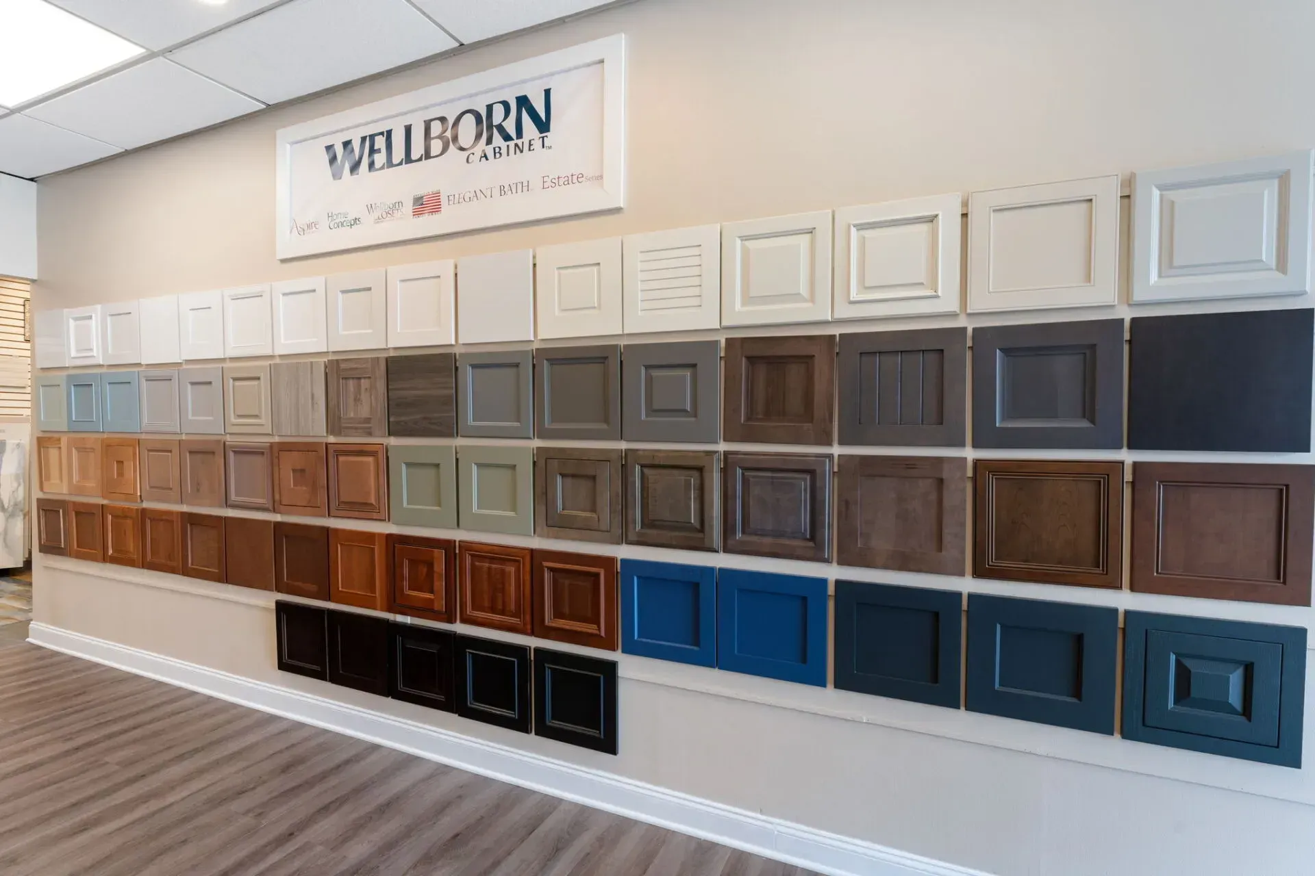 Showroom wall of cabinet door samples in white, gray, brown, and blue finishes under a Wilborn sign  In Bucks County PA