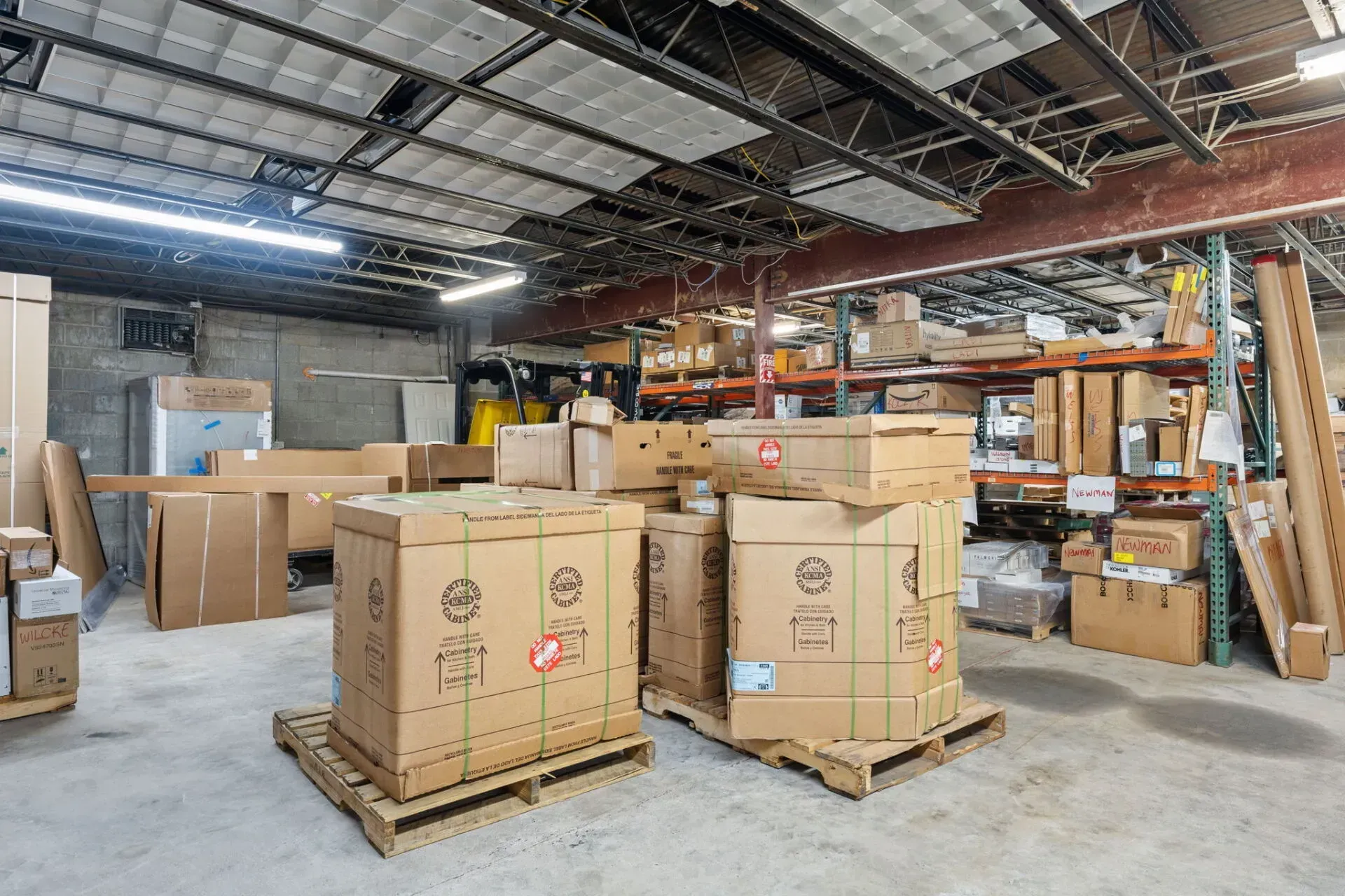 Warehouse interior with stacked cardboard crates on wooden pallets and industrial shelving in the background  In Bucks County PA