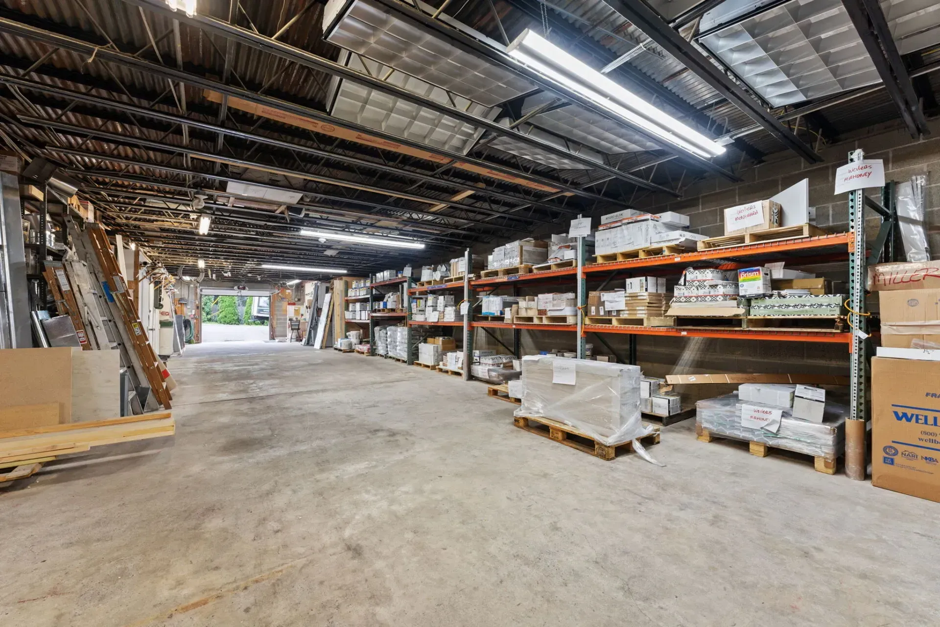 Large warehouse interior with metal shelving, stacked boxes, and pallets on a concrete floor  In Bucks County PA