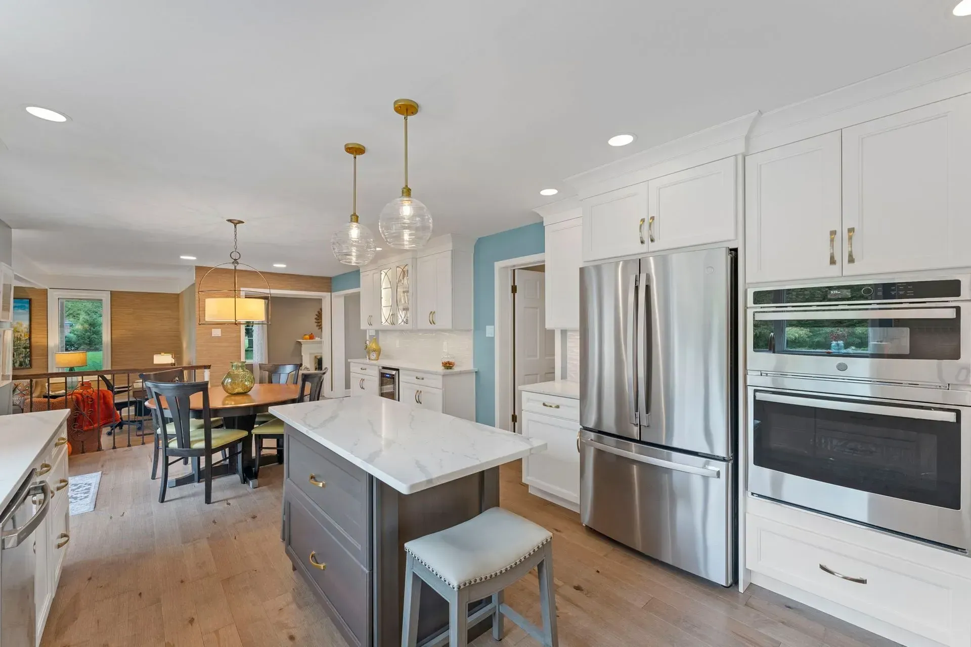 Bright modern kitchen with white cabinets, stainless steel appliances, island, and adjacent dining area  In Bucks County PA