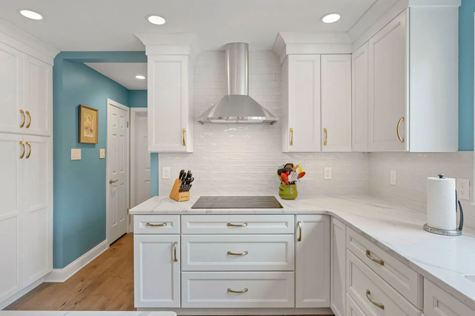 Bright white kitchen with light blue accents, stainless range hood, and fruit on the counter  In Bucks County PA