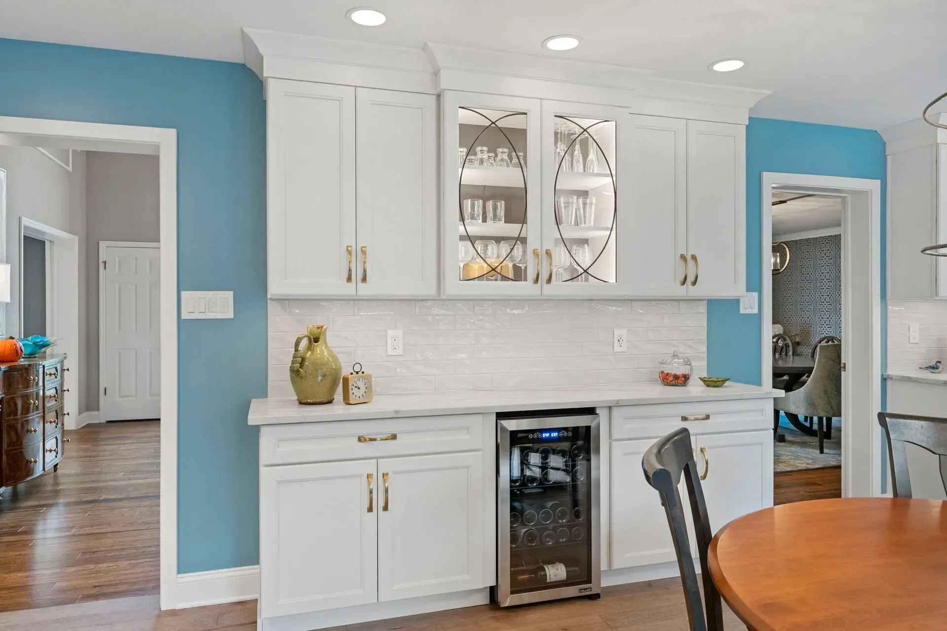 Bright kitchen with white cabinets, blue walls, and a built-in wine fridge  In Bucks County PA