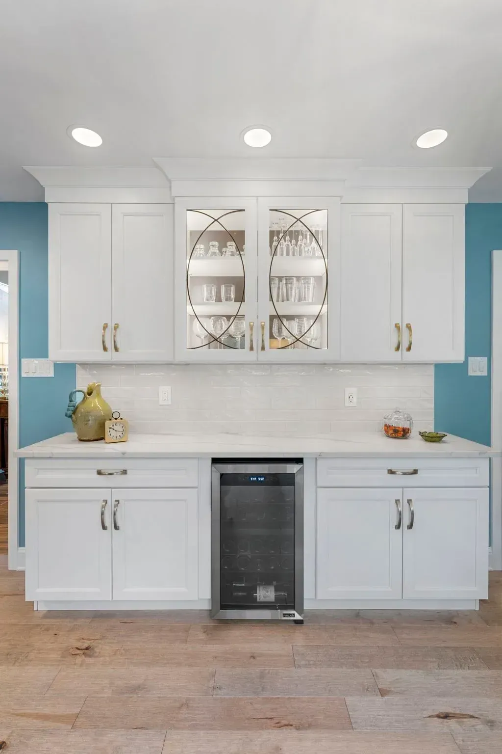 White kitchen with teal walls, glass-front cabinets, sink, and under-counter wine cooler  In Bucks County PA
