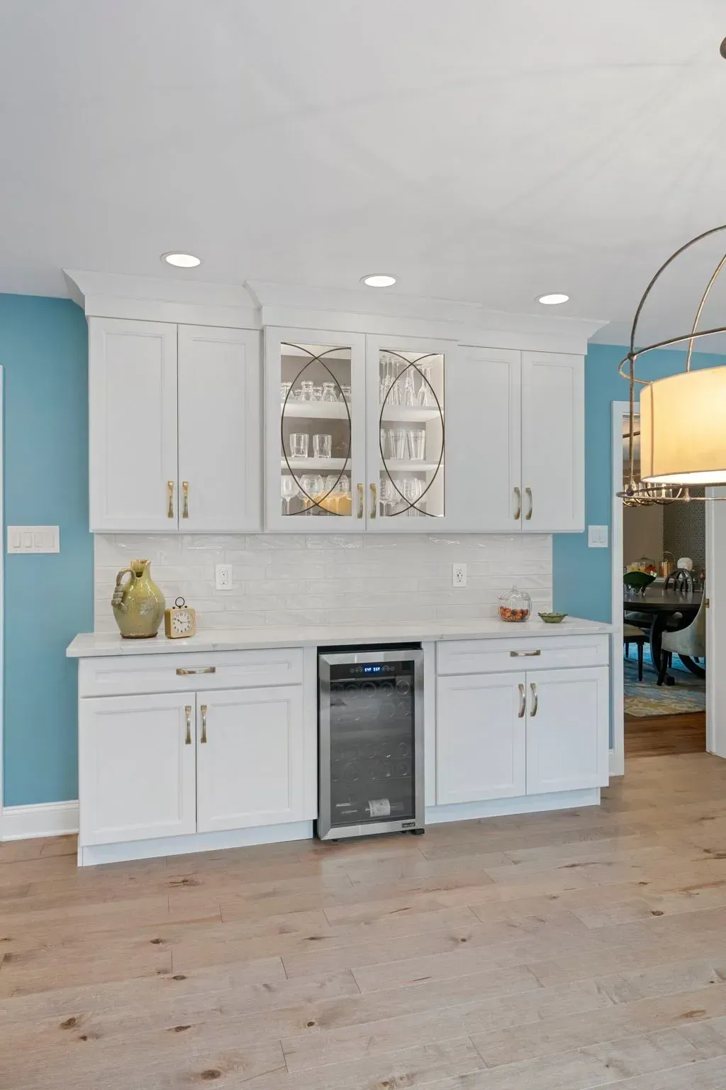 Bright white kitchen with light blue walls, white cabinets, and a stainless dishwasher on wood floors  In Bucks County PA