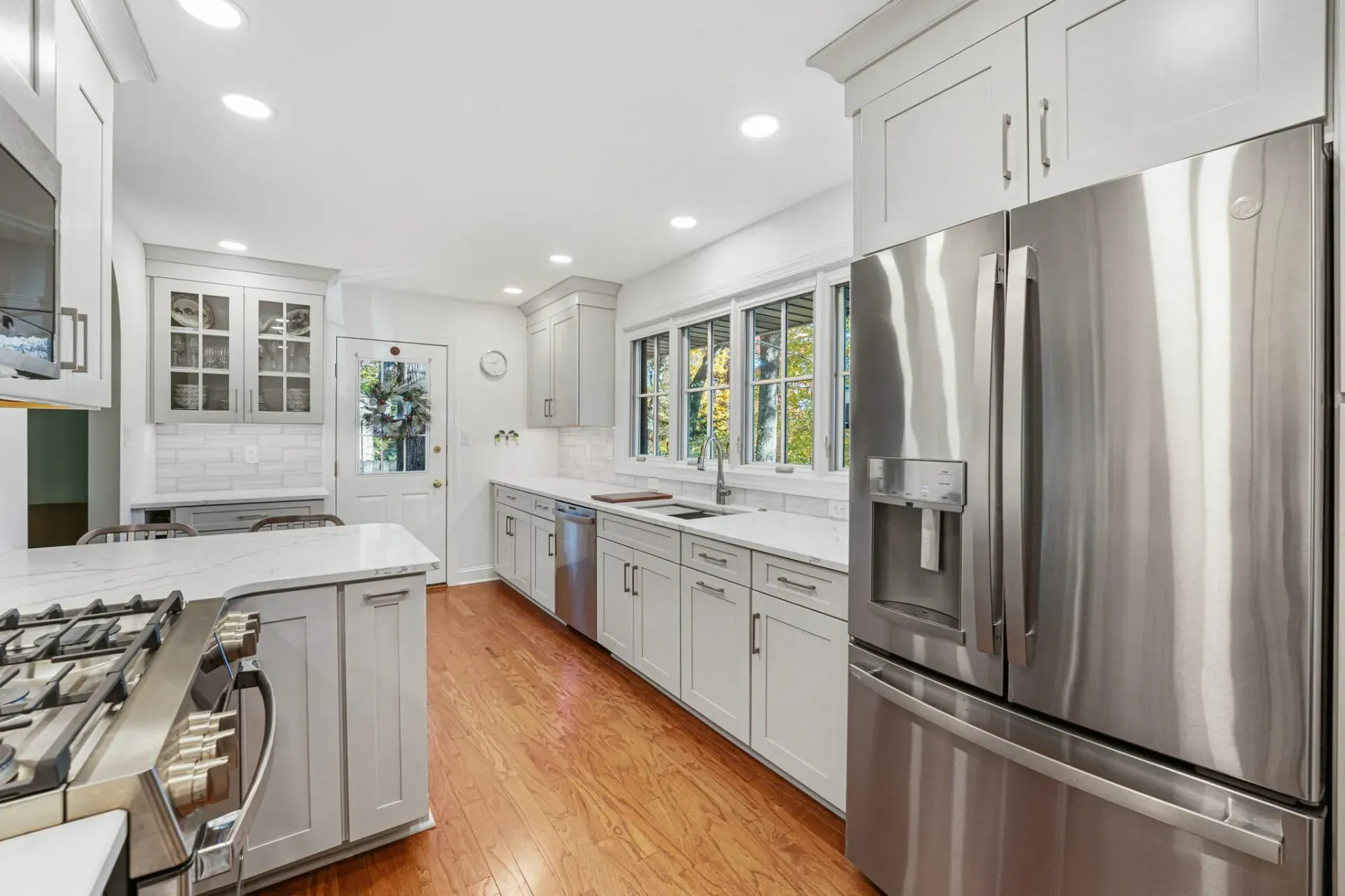 Bright modern kitchen with stainless steel appliances, white cabinets, and hardwood floors in Bucks County PA