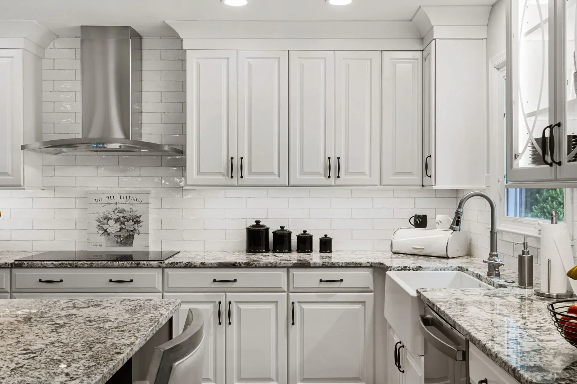 Bright white kitchen with marble countertops, stainless range hood, and white cabinets In Bucks County PA