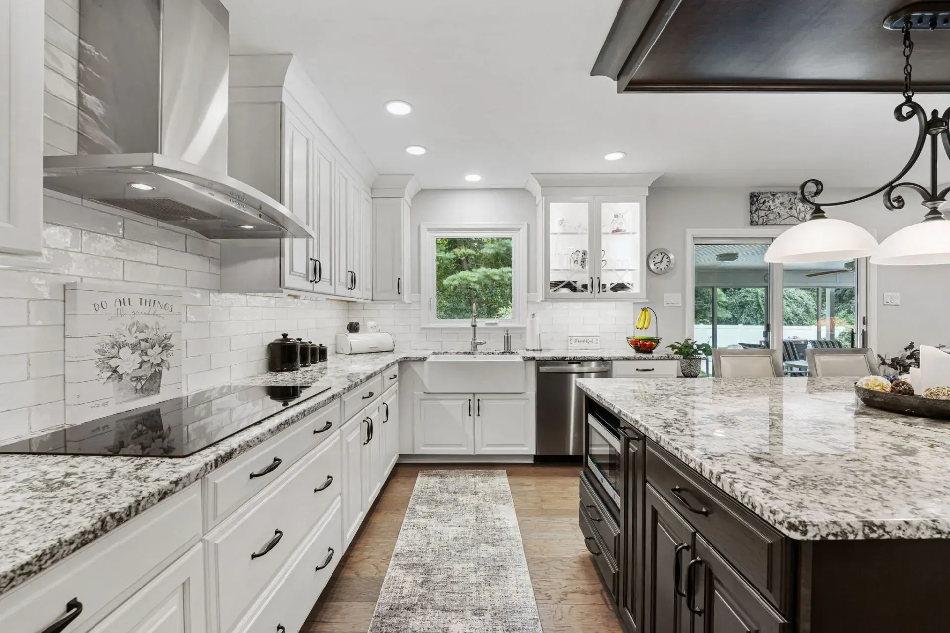 Bright modern kitchen with white cabinets, granite countertops, stainless appliances, and a large island In Bucks County PA