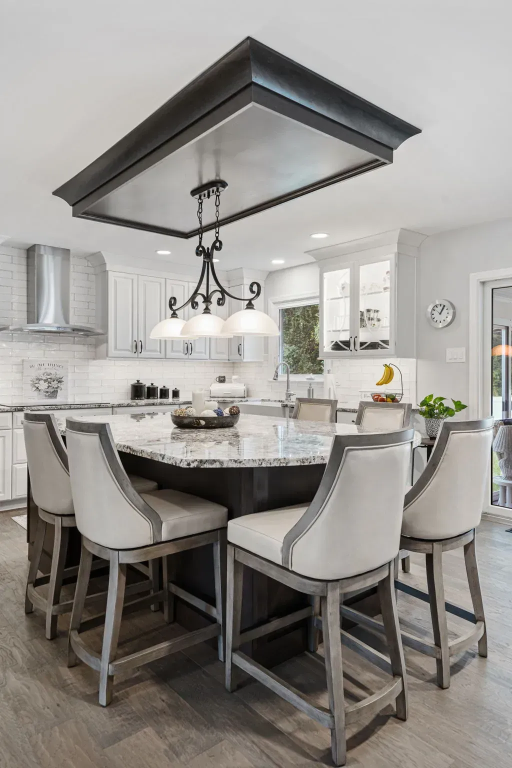 Modern kitchen with a large island, pendant light, and four upholstered stools In Bucks County PA