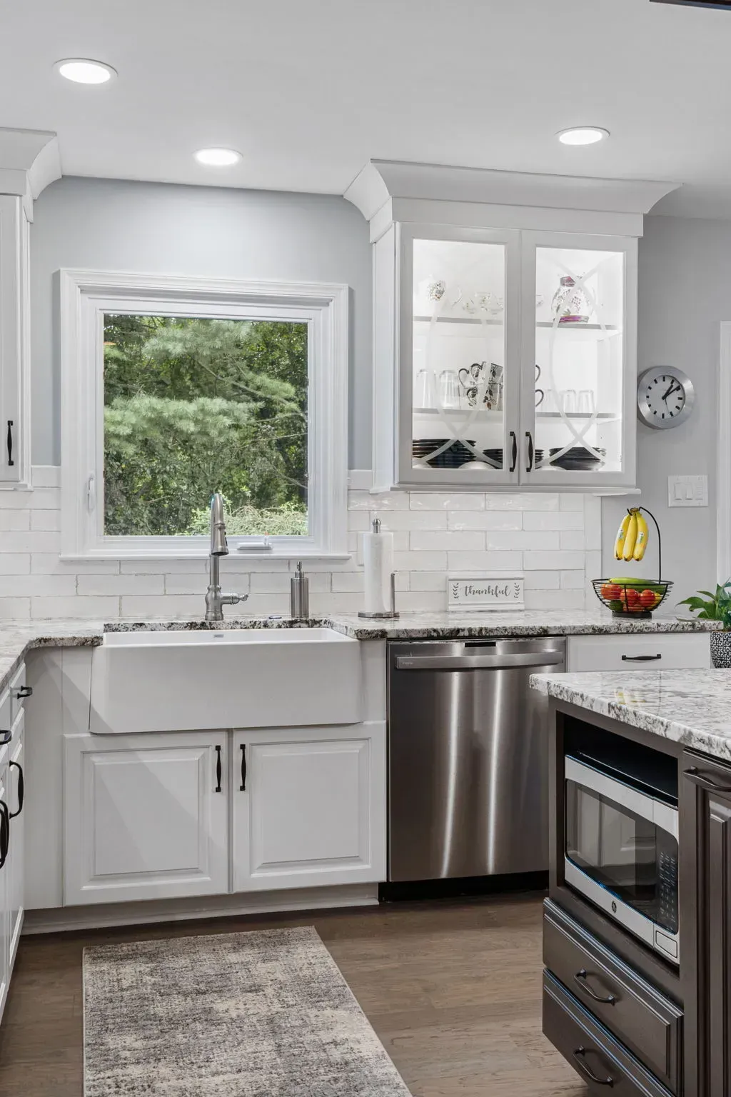 Modern kitchen with white cabinets, stainless appliances, and a window over the sink In Bucks County PA