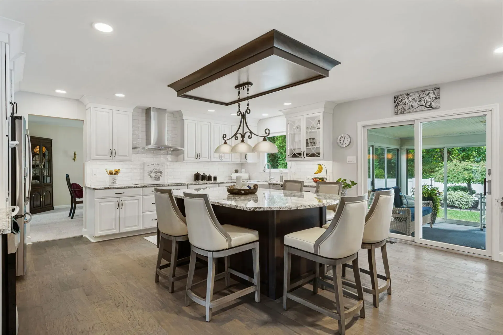 Bright modern kitchen with a dark wood island, white cabinets, and sliding glass doors to a patio In Bucks County PA