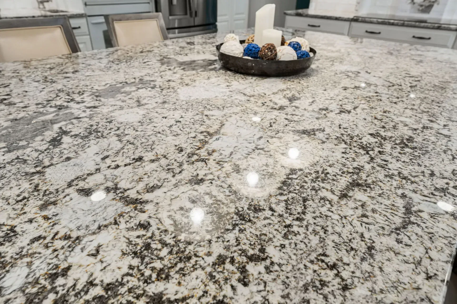 Kitchen island with speckled granite countertop and a decorative bowl centerpiece In Bucks County PA