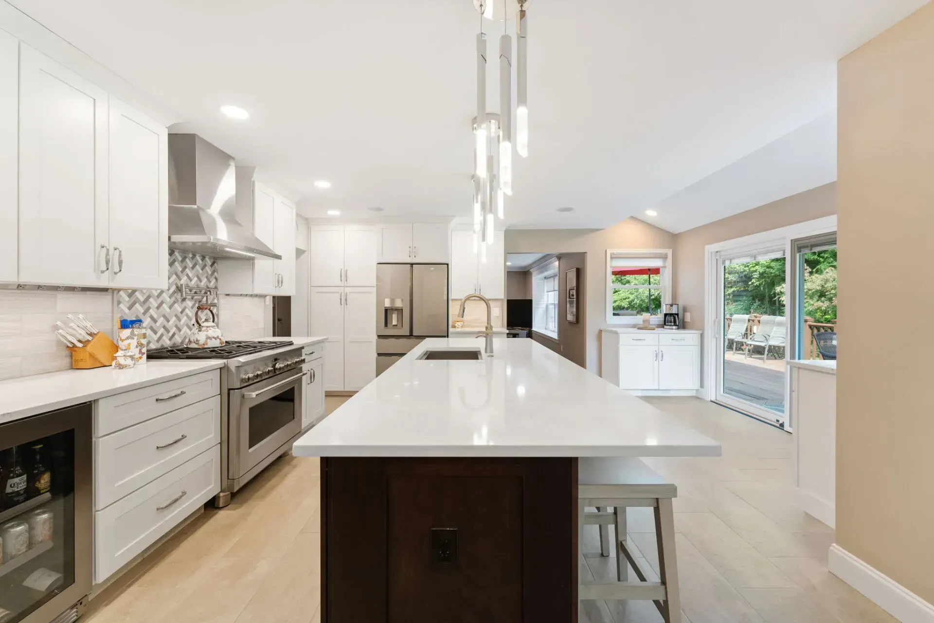 Bright modern kitchen with white cabinets, large island, stainless appliances, and pendant lights In Bucks County PA