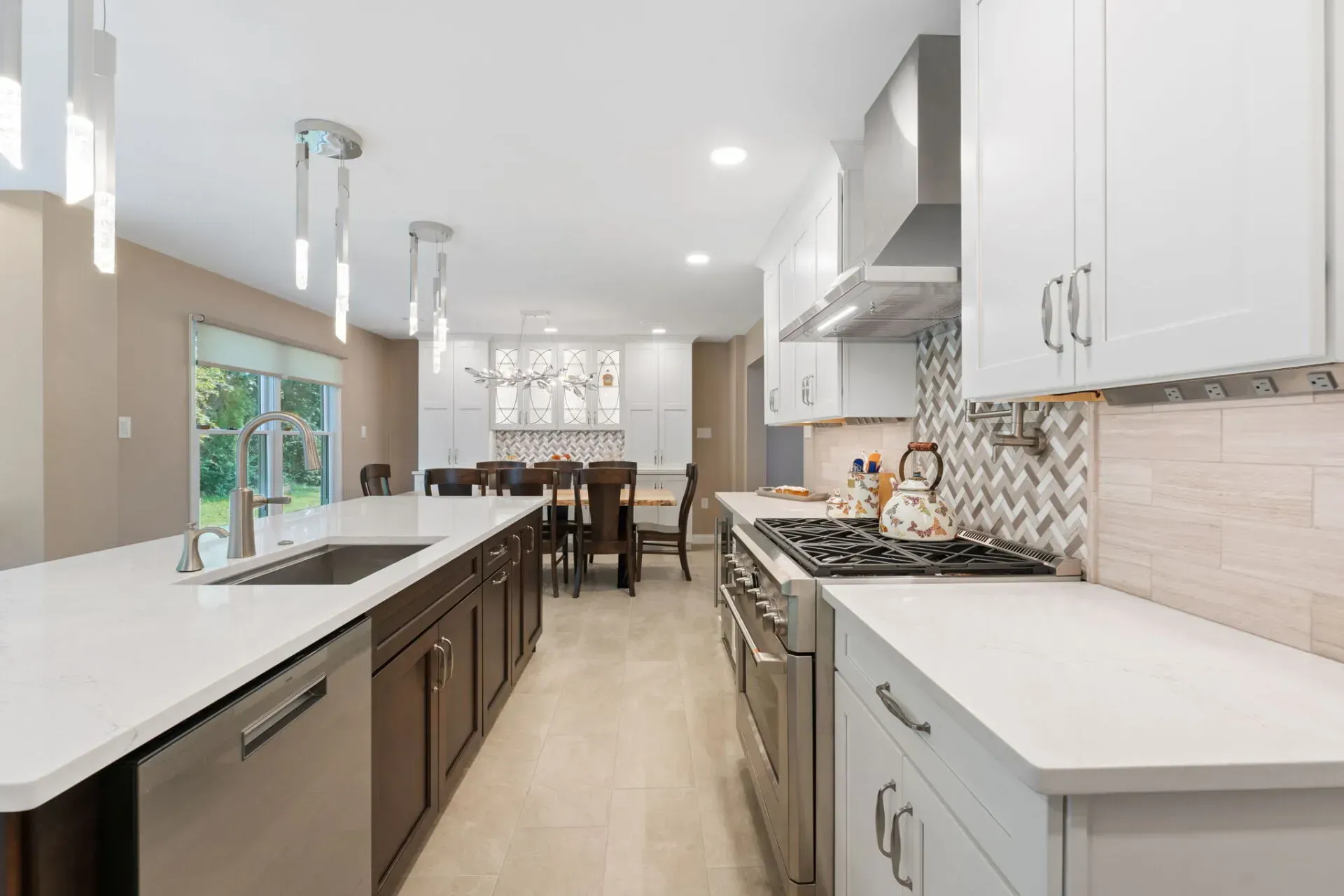 Bright modern kitchen with white cabinets, large island, and dining area in back In Bucks County PA