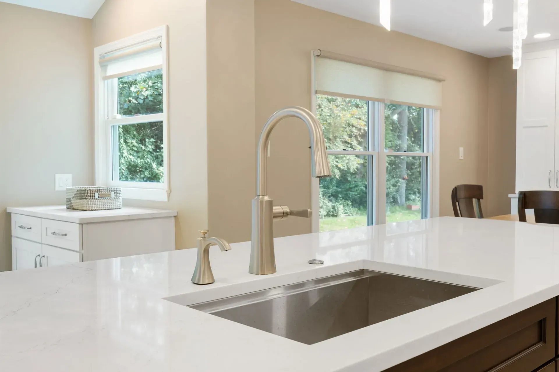 Bright modern kitchen with white countertops, sink, and large windows letting in natural light In Bucks County PA