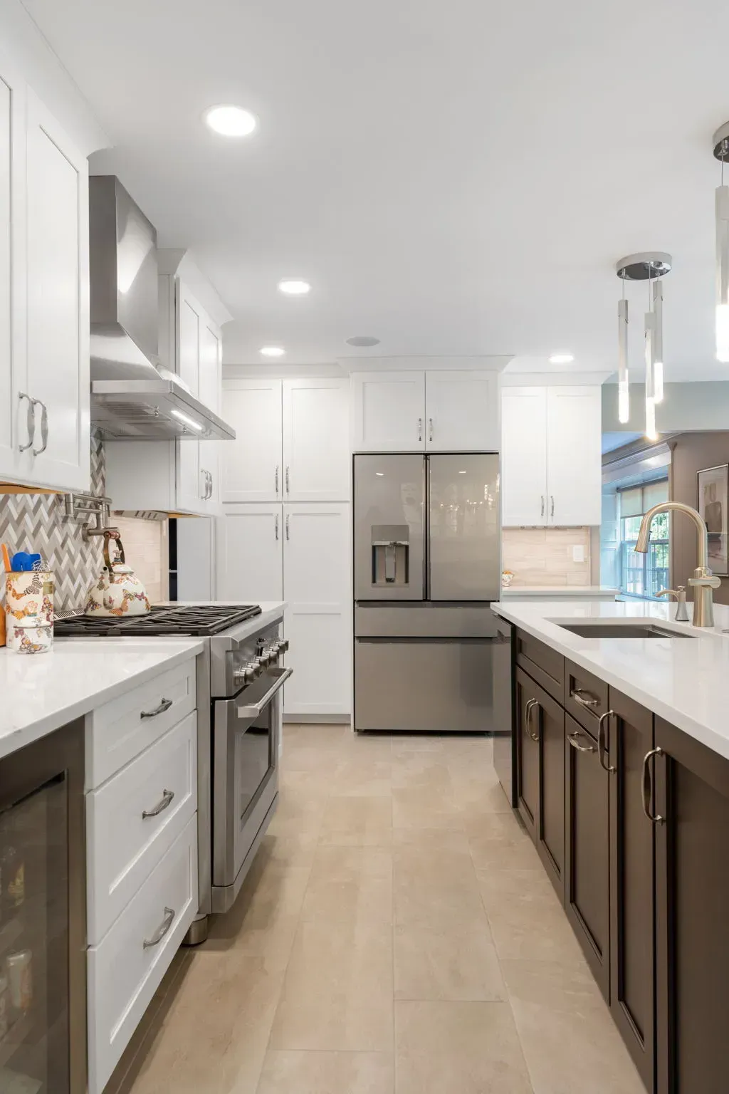 Bright modern kitchen with white cabinets, stainless steel fridge, and dark island cabinets In Bucks County PA