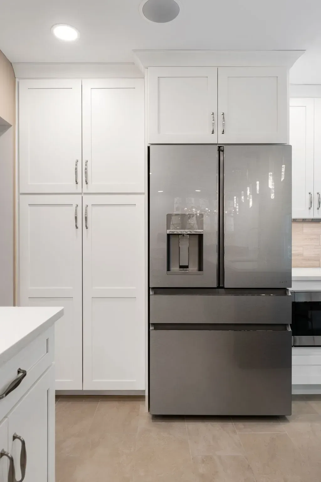 Bright kitchen with white cabinets and a stainless steel French-door refrigerator In Bucks County PA