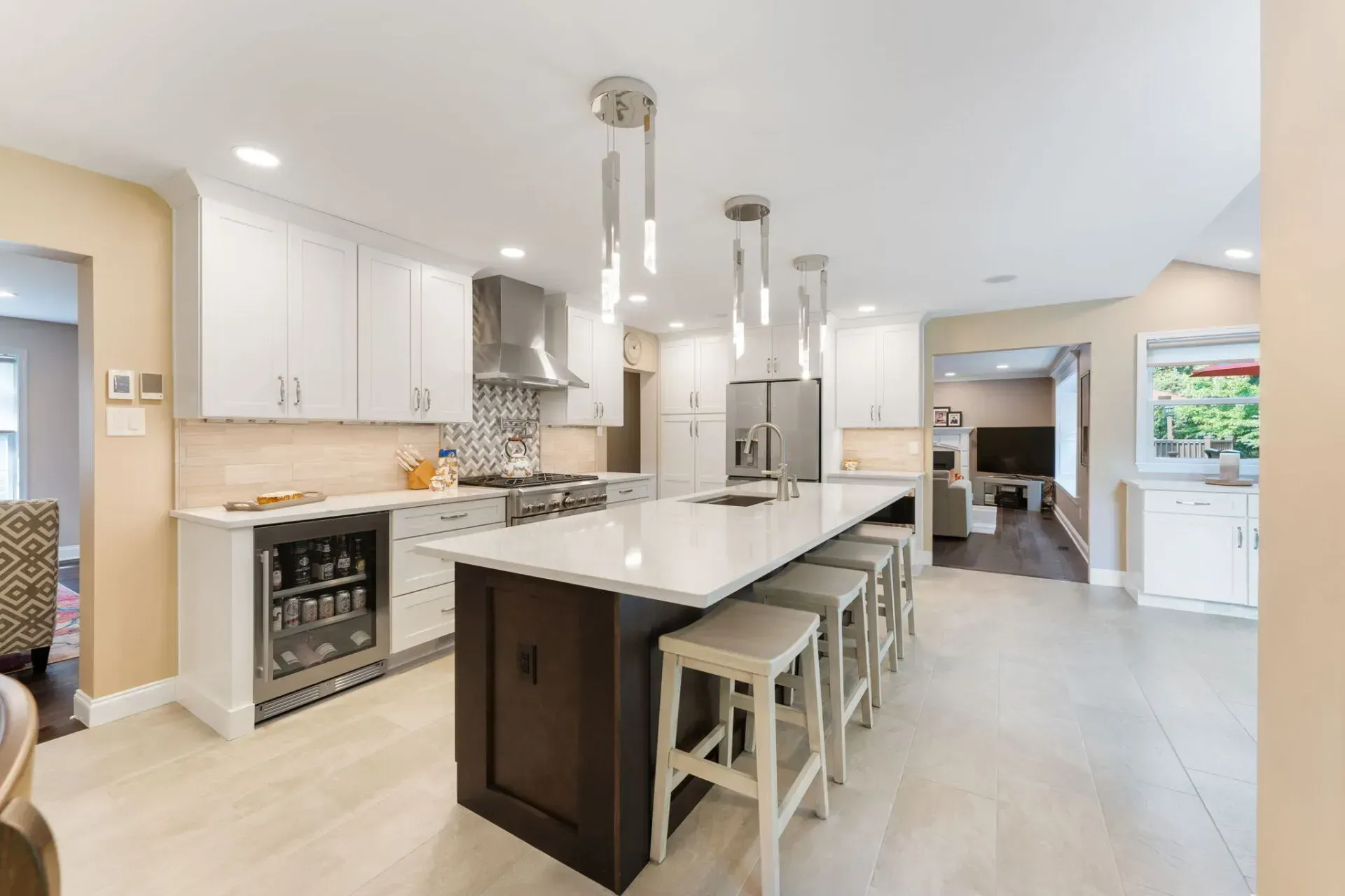 Bright modern kitchen with large island, white cabinets, stainless appliances, and pendant lights In Bucks County PA