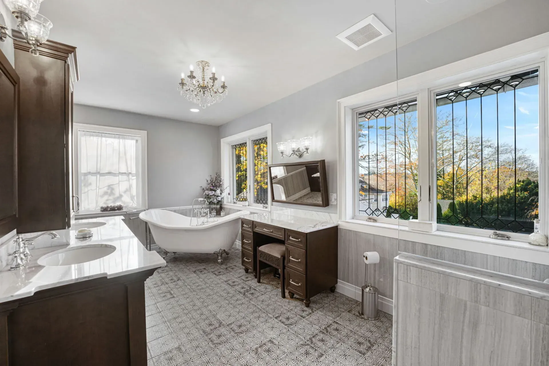 Bright bathroom with freestanding tub, vanity, large windows, and floral wallpaper in Bucks County PA