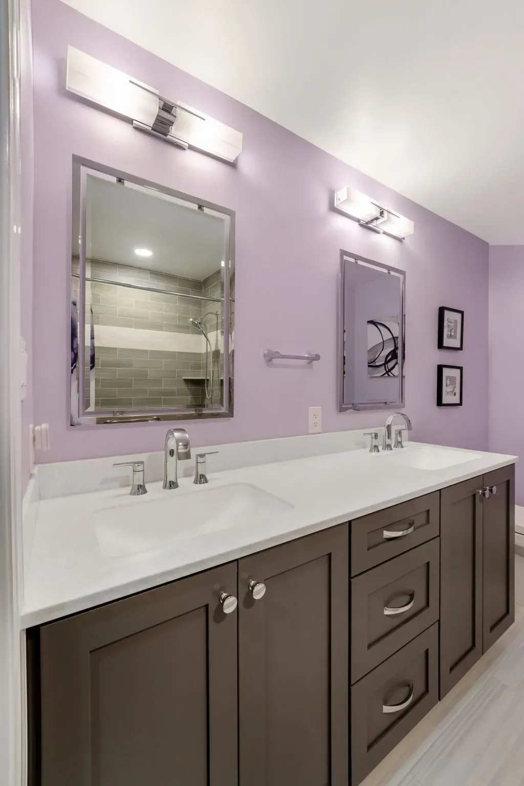 Modern bathroom with lavender walls, double vanity, large mirror, and white countertop drawers In Bucks County PA