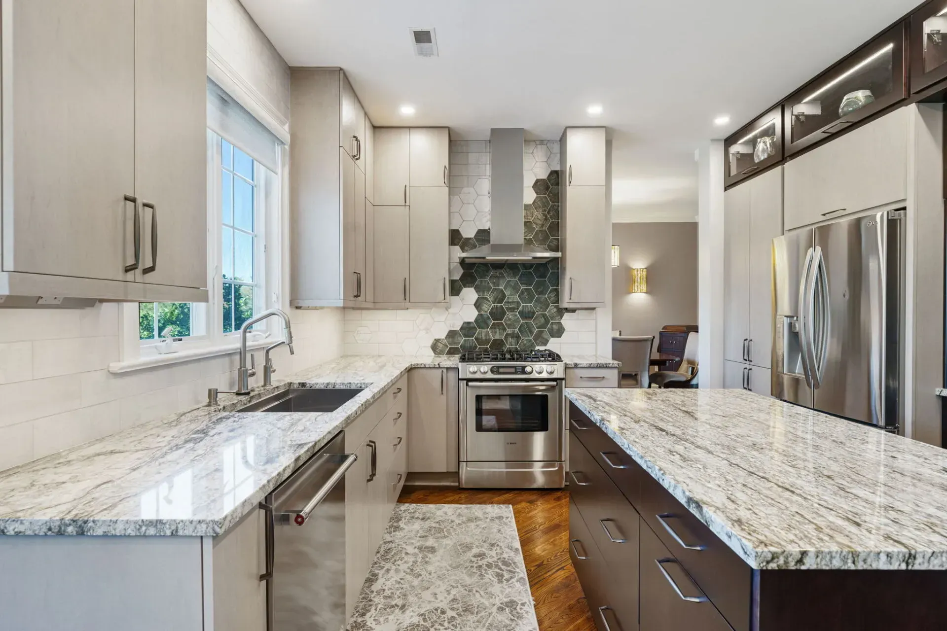 Modern kitchen with white cabinets, granite countertops, stainless steel appliances, and mosaic tile backsplash In Bucks County PA
