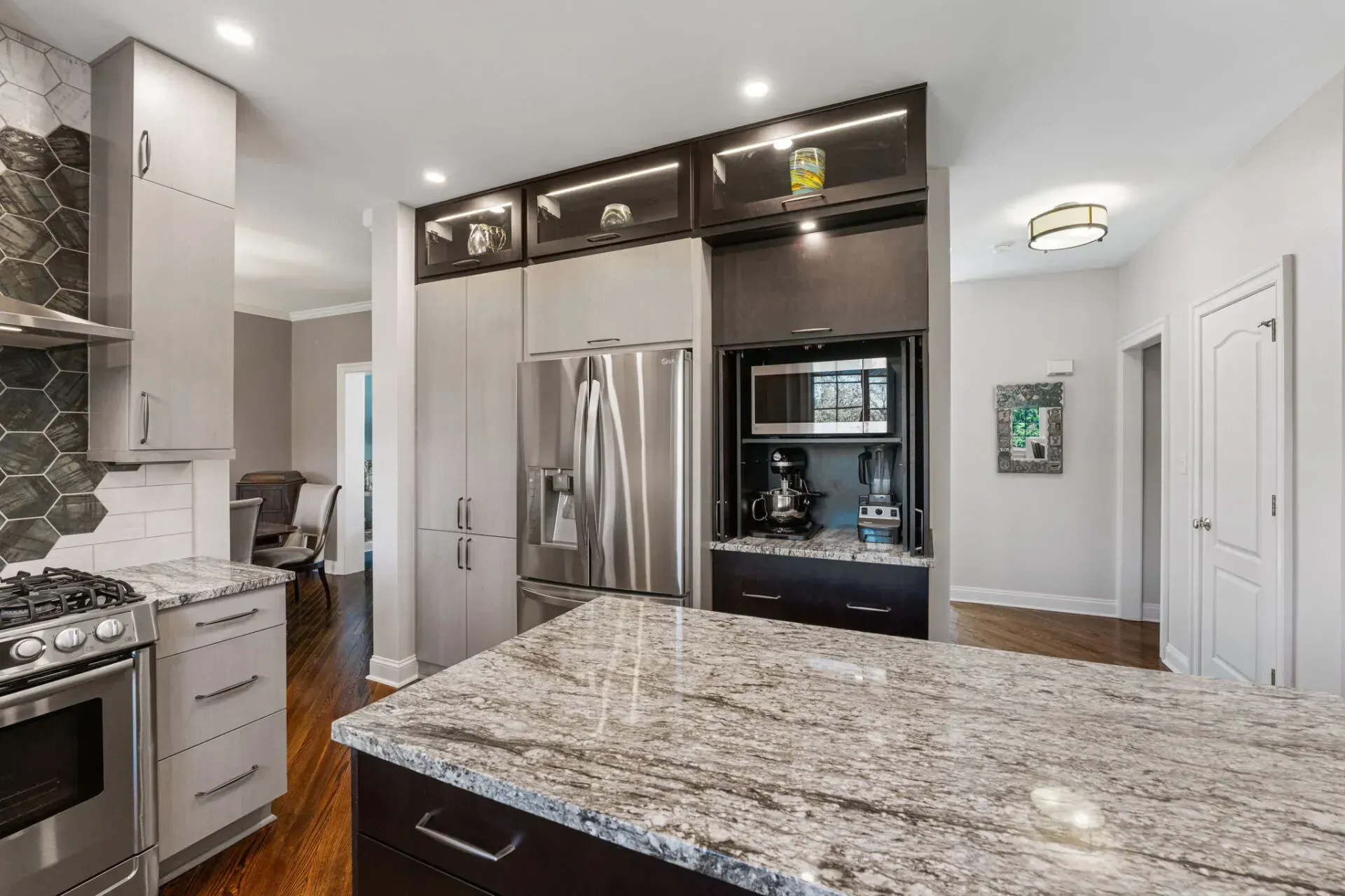 Modern kitchen with granite island, stainless steel appliances, and dark wood cabinets In Bucks County PA