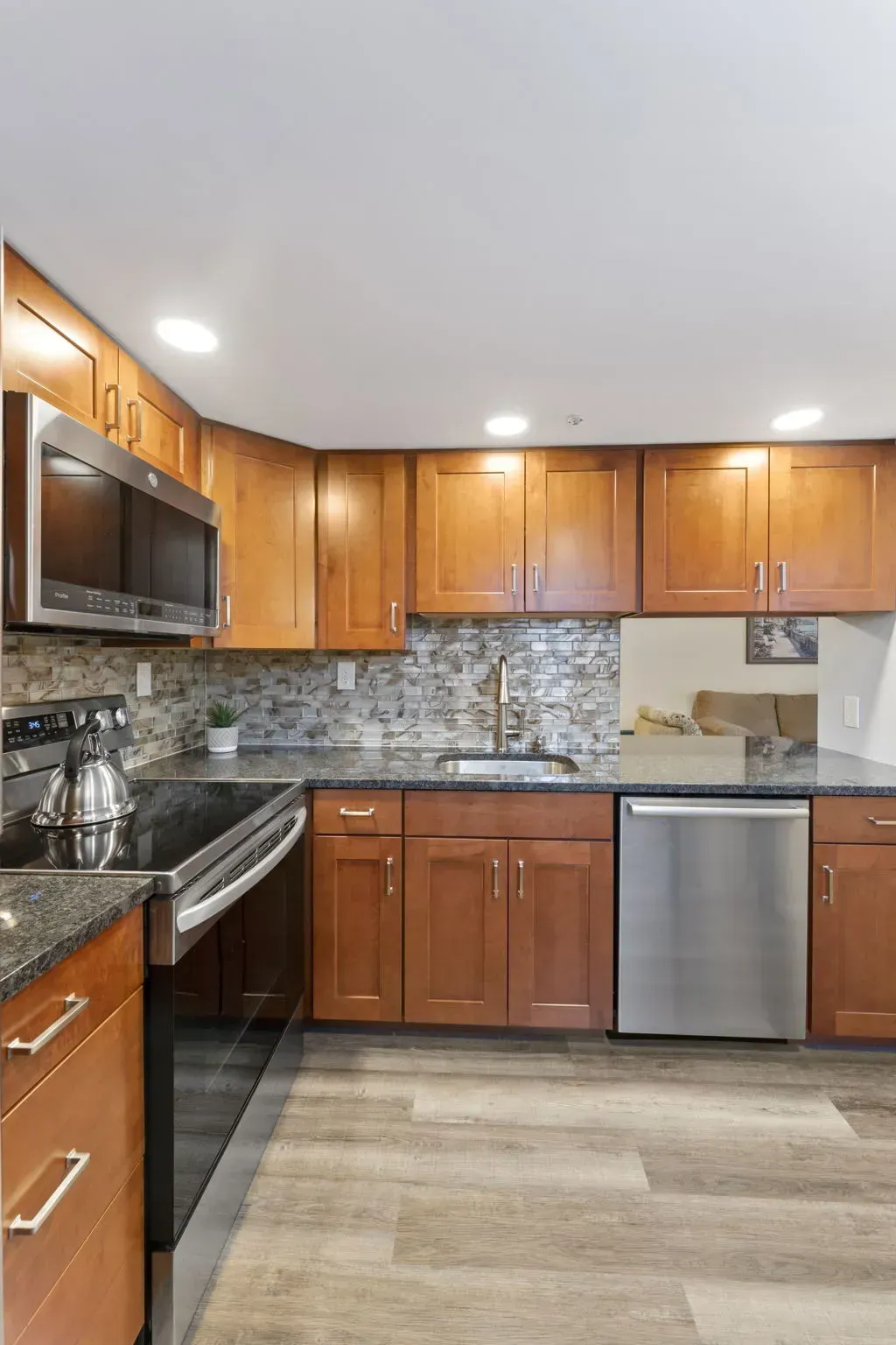 Modern kitchen with wood cabinets, stainless steel appliances, and a tiled backsplash In Bucks Country PA