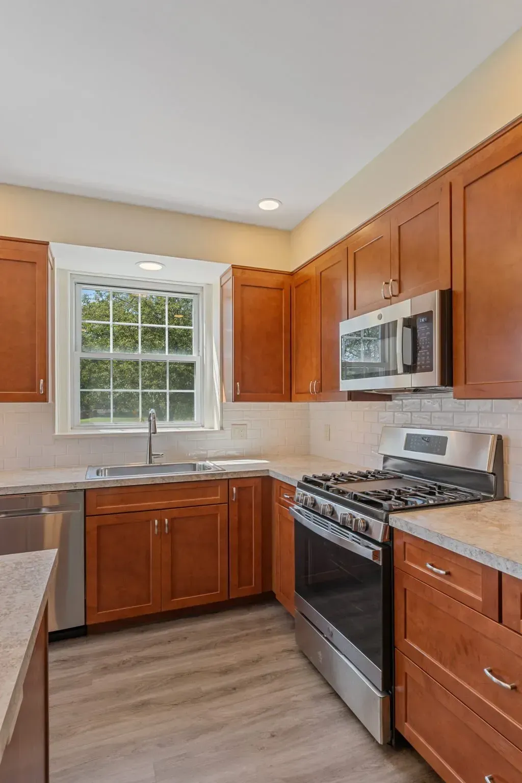 Bright kitchen with wood cabinets, stainless steel appliances, and a window over the sink  In Bucks County PA