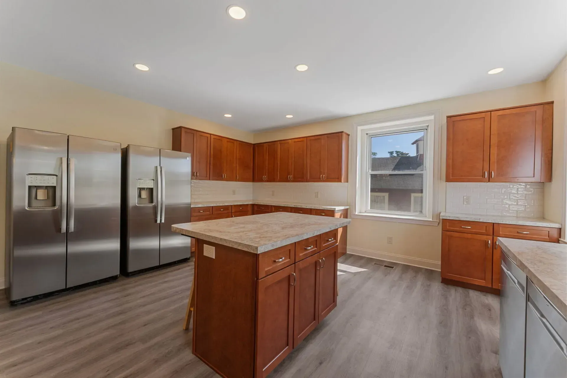 Spacious modern kitchen with stainless steel appliances, wood cabinets, and a central island with granite countertop  In Bucks County PA