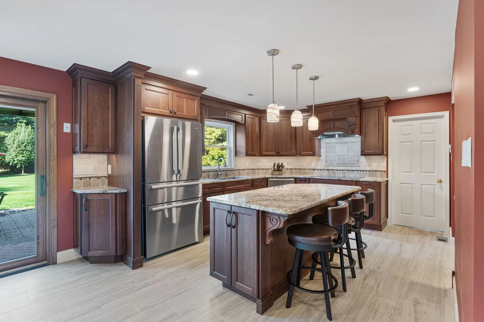 Modern kitchen with dark wood cabinets, stainless steel appliances, island, and barstools  In Bucks County PA