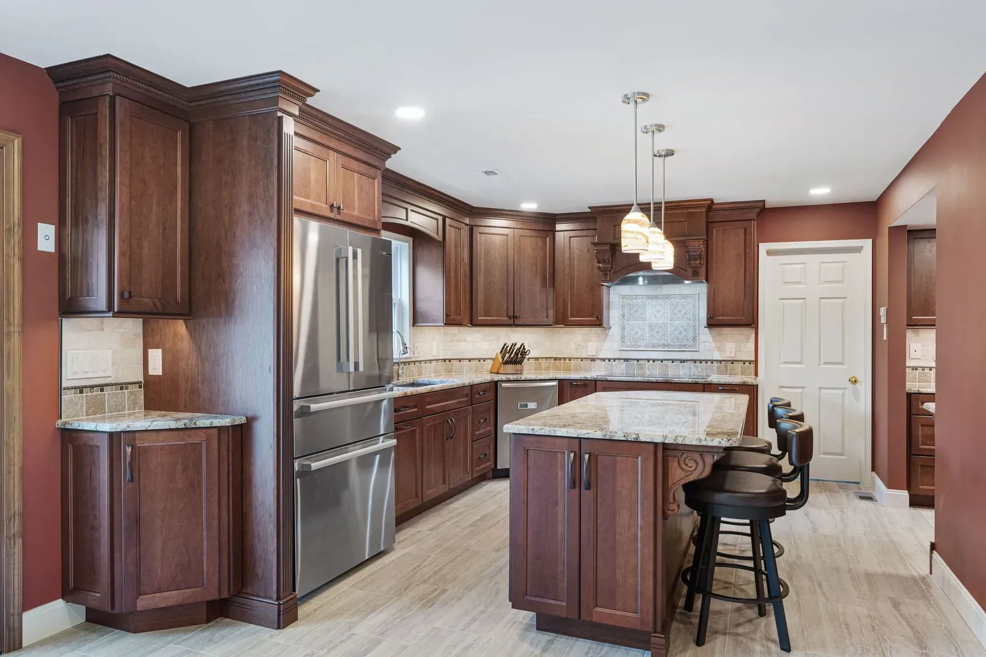 Modern kitchen with dark wood cabinets, stainless steel appliances, island, and light countertops In Bucks Country PA