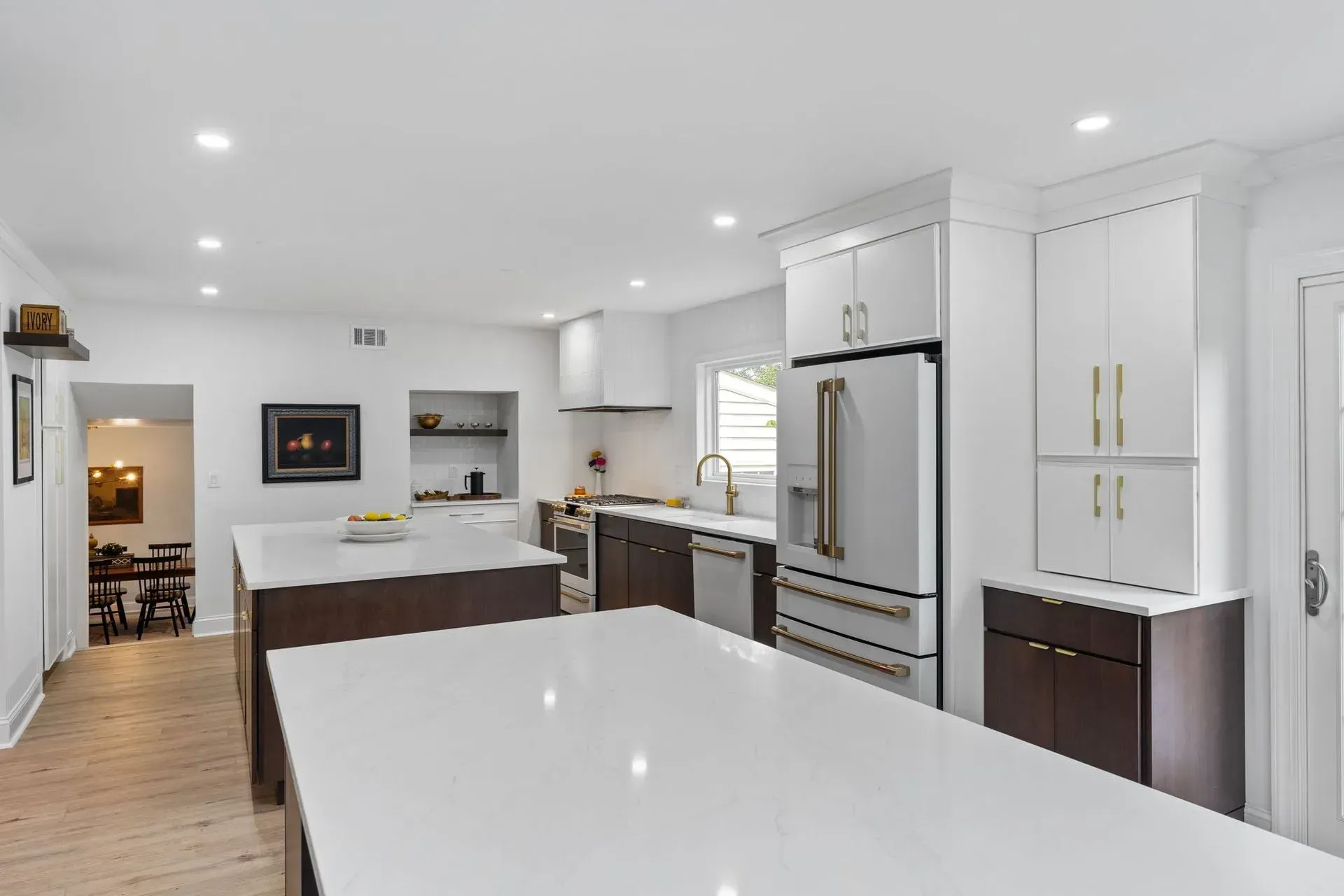 Bright modern kitchen with white cabinets, stainless steel fridge, and large island countertop In Bucks County PA