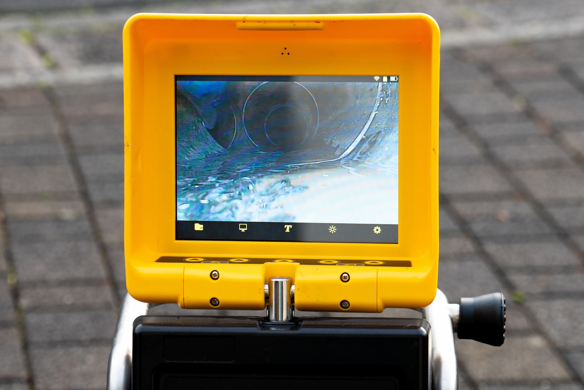 Yellow device displaying a blurry interior view. The device is mounted on a black and white base.