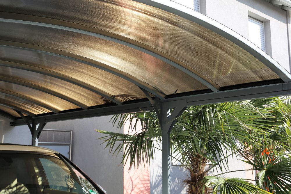 Carport With Arched, Brown-tinted Roof Over a Vehicle — Dachboe Your Handyman In Townsville, QLD
