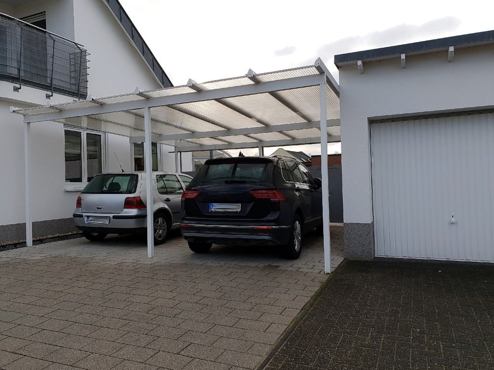 Cars Parked Under a White Carport Next to a Garage on a Paved Driveway — Dachboe Your Handyman In Townsville, QLD