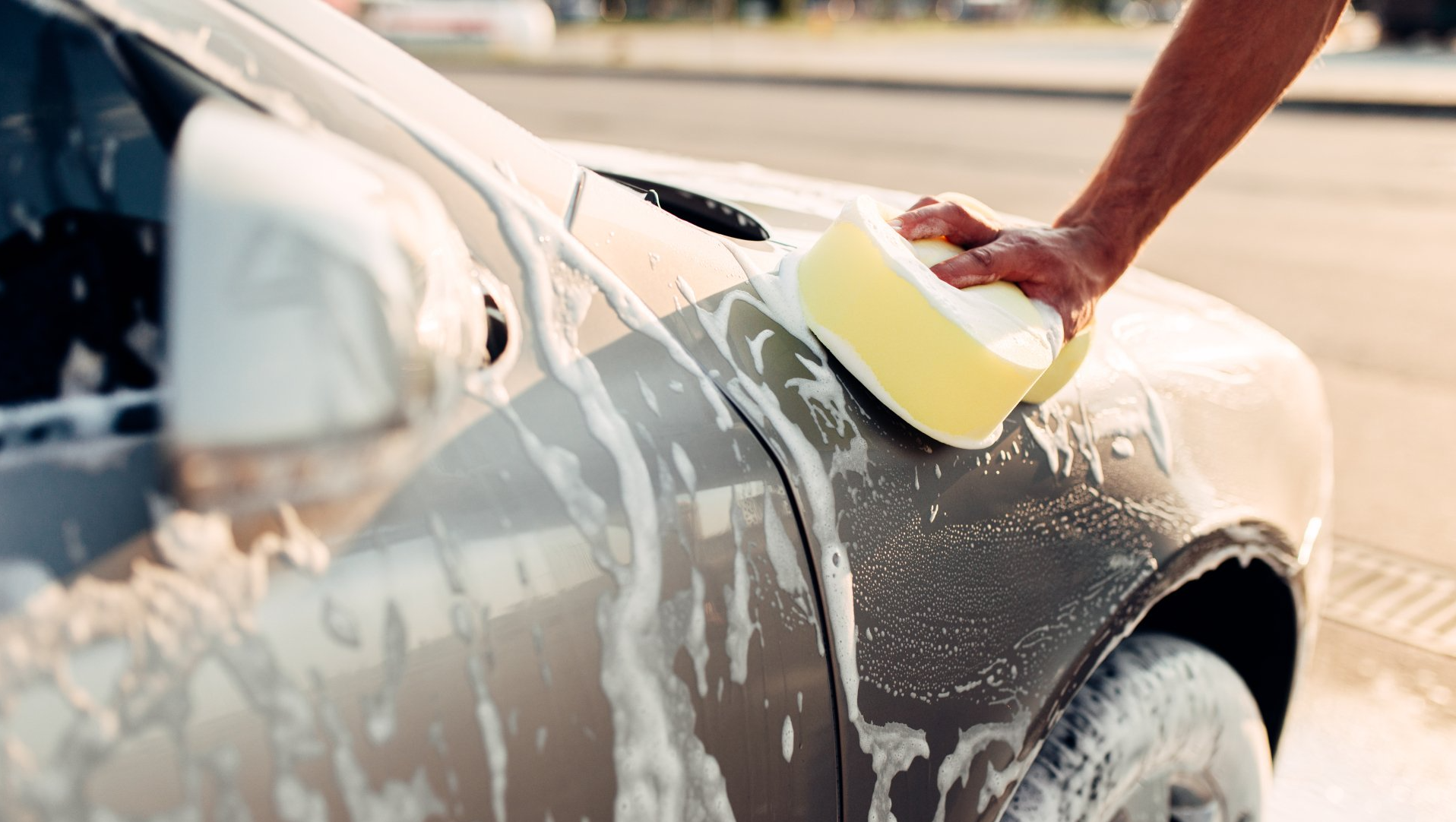 man foaming a car with a sponge