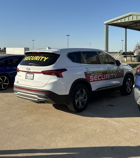 White security SUV parked in a lot, with “SECURITY” printed on the rear window and side.