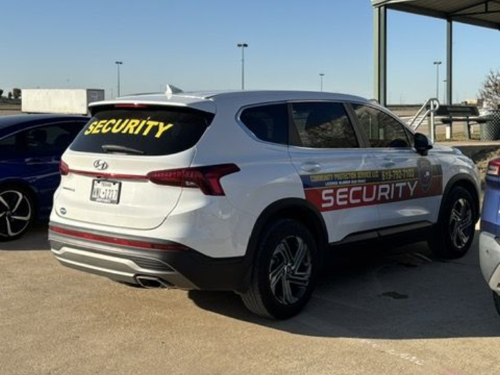 White security SUV parked outdoors in a lot, with “SECURITY” markings on the rear window and side.