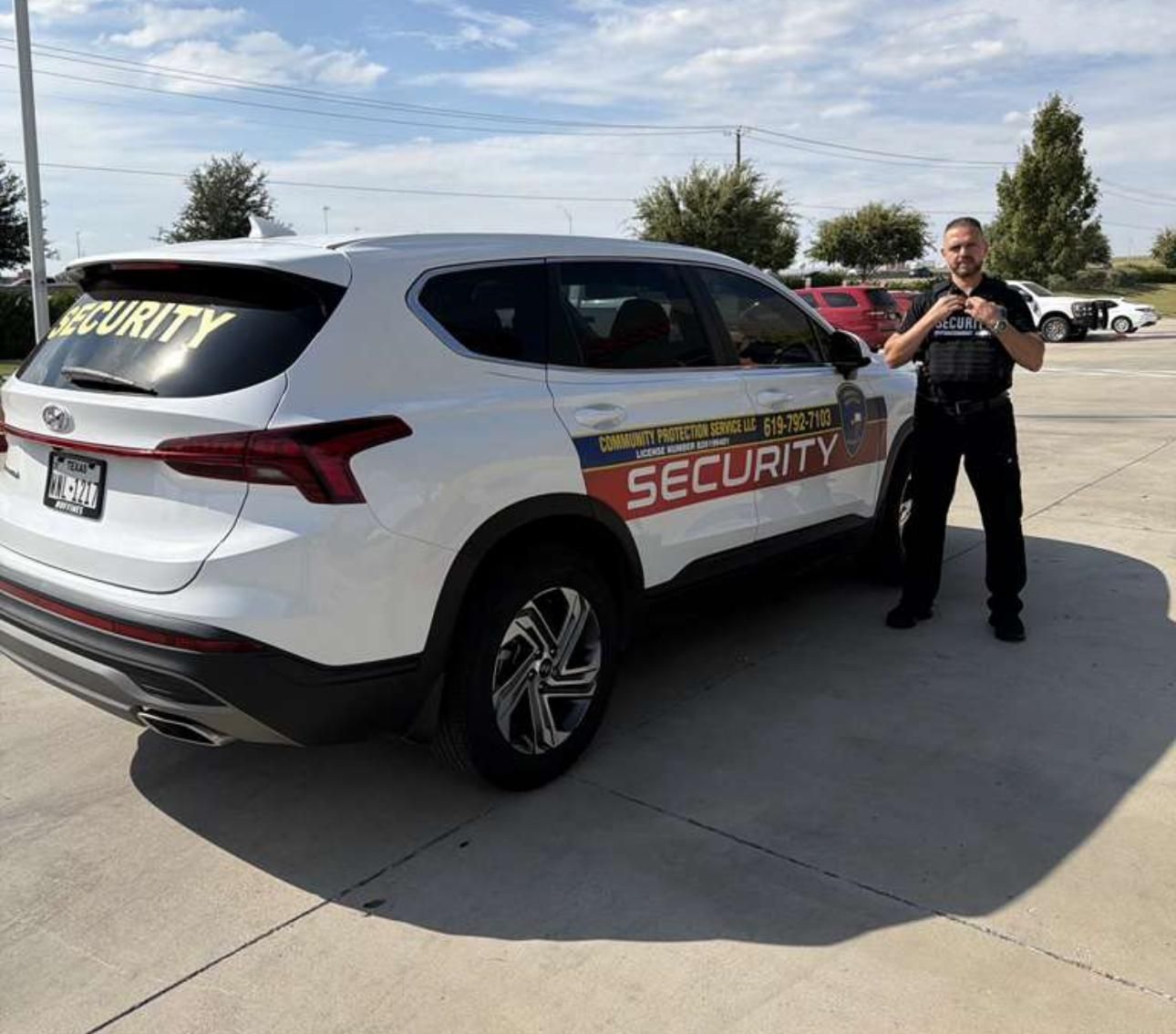 Security guard standing beside a white security SUV in a parking lot