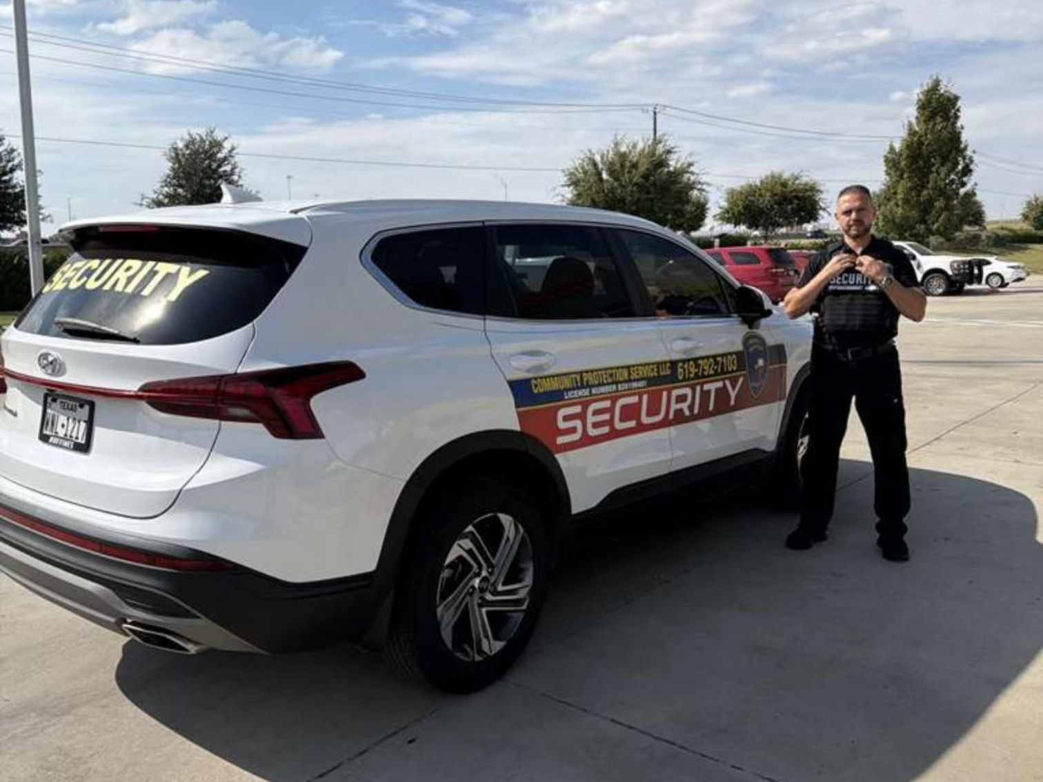 Security SUV and uniformed guard standing beside it in a parking lot