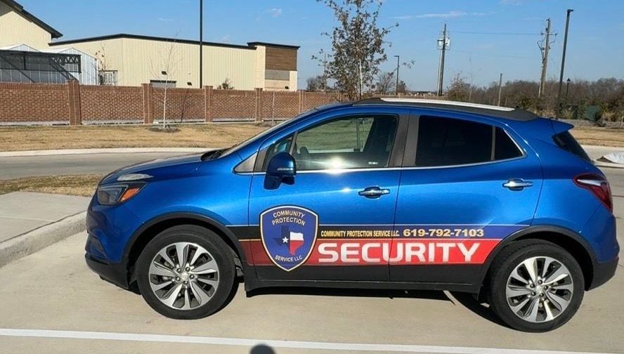 Blue security SUV parked outdoors with large red “SECURITY” lettering on the side.