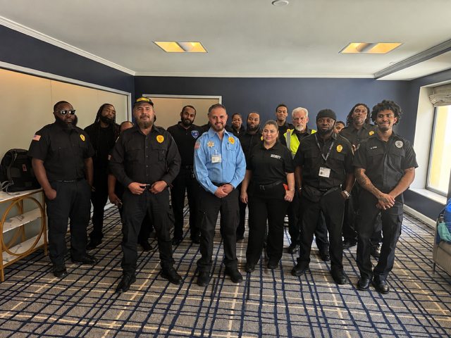 Group of uniformed officers standing together in a conference room, facing the camera.