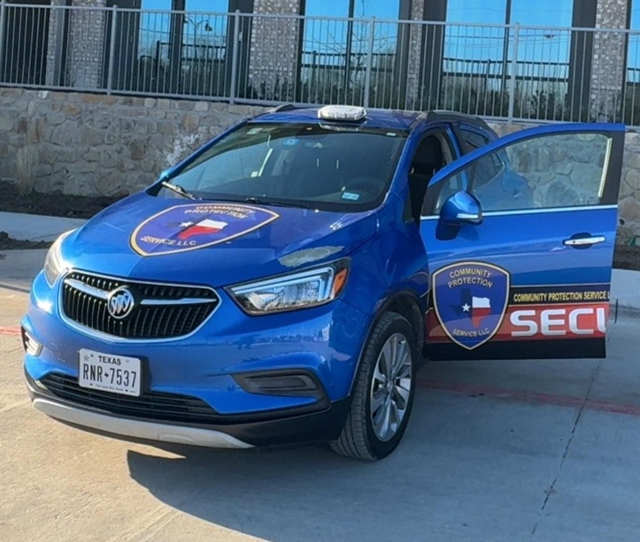 Blue security patrol SUV parked outdoors with driver door open, showing SECI logo on the side.
