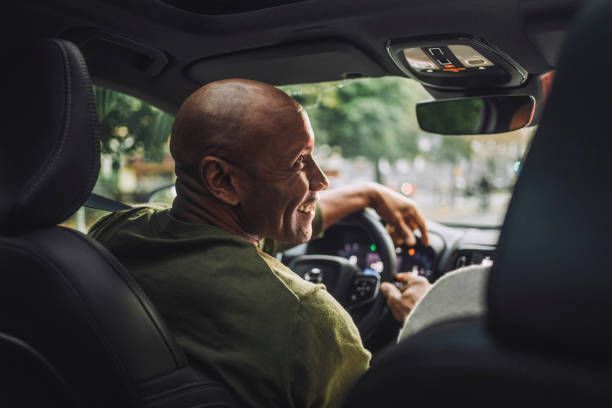 A man is sitting in the driver's seat of a car.