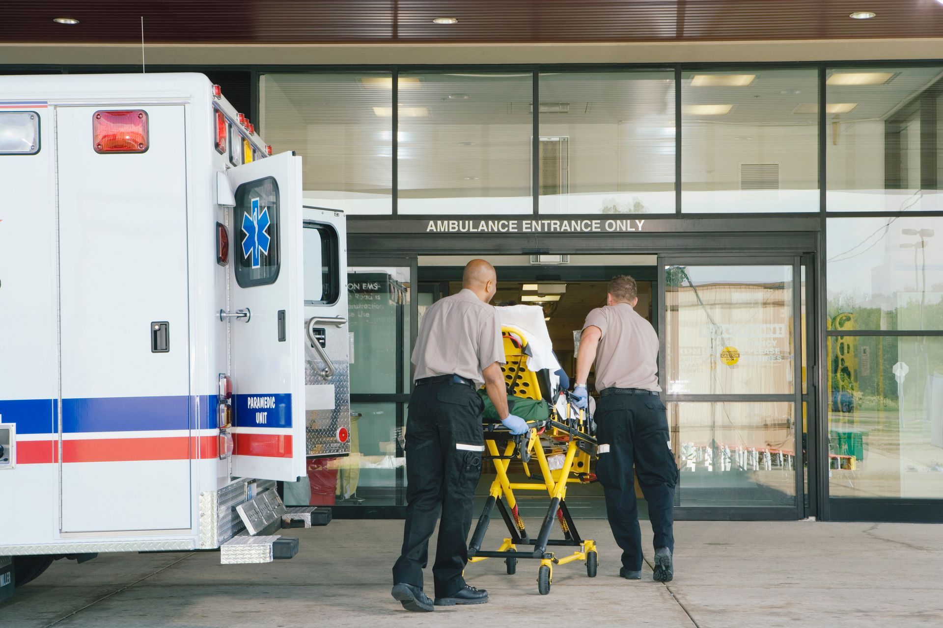 A group of paramedics are carrying an ambulance into a hospital.