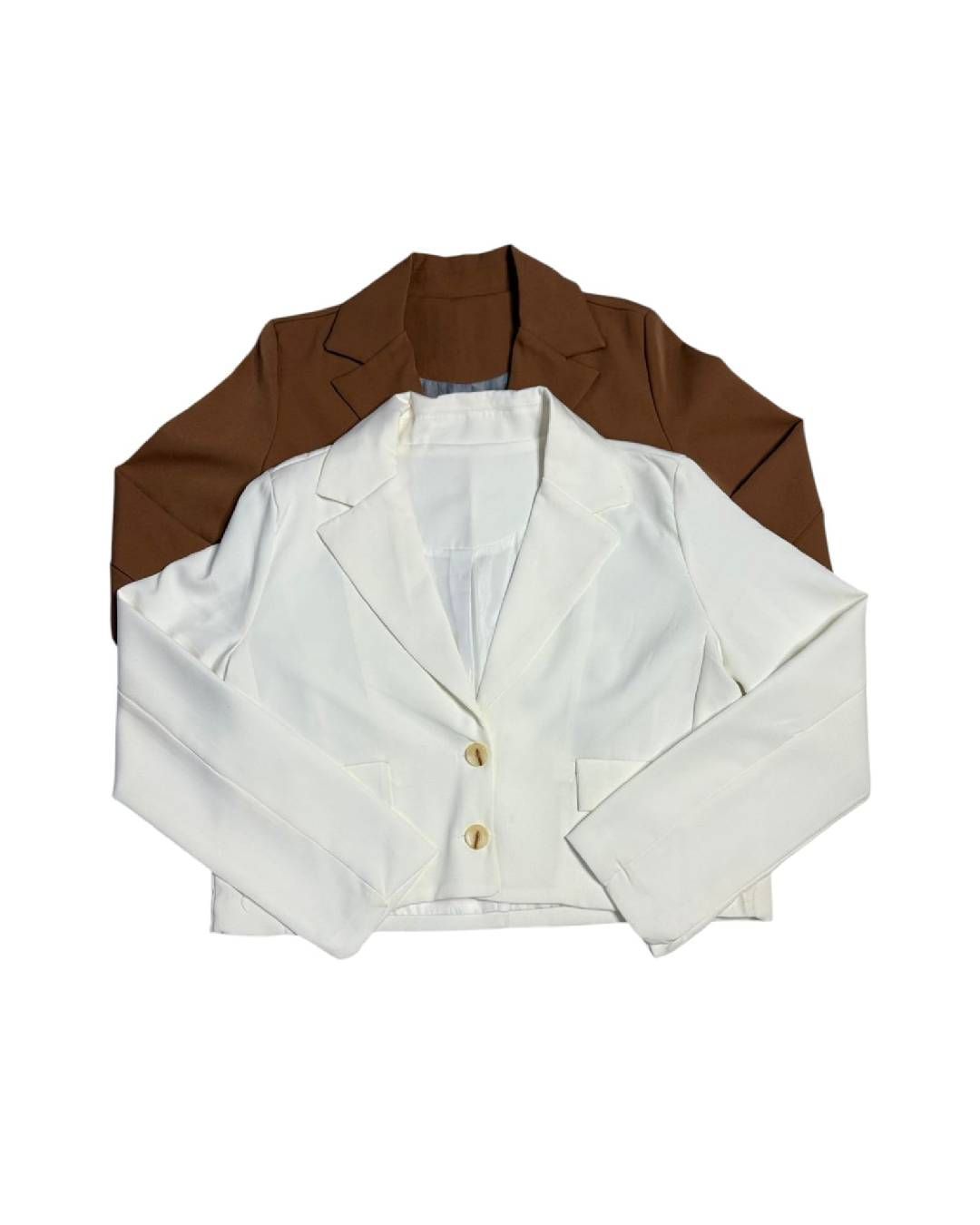 Dos blazers, uno blanco y otro marrón, superpuestos sobre un fondo blanco.