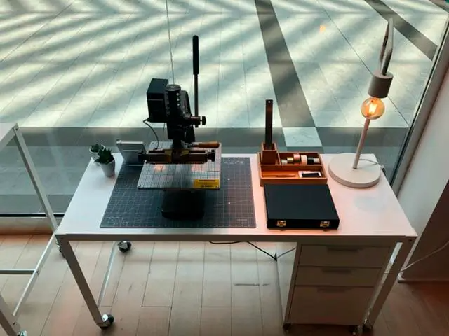 A desk with a microscope and a lamp on it