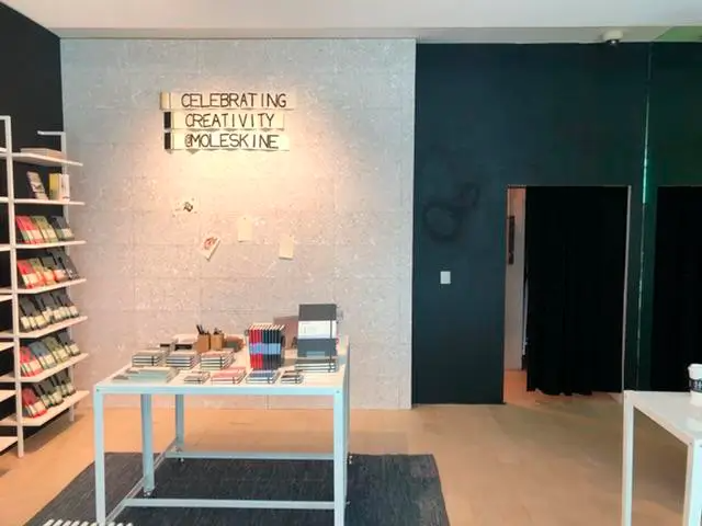 A sign on the wall says celebrating creativity moleskine